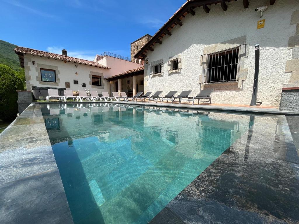 a swimming pool in front of a house at Can Vilallonga in Sant Feliu de Pallerols