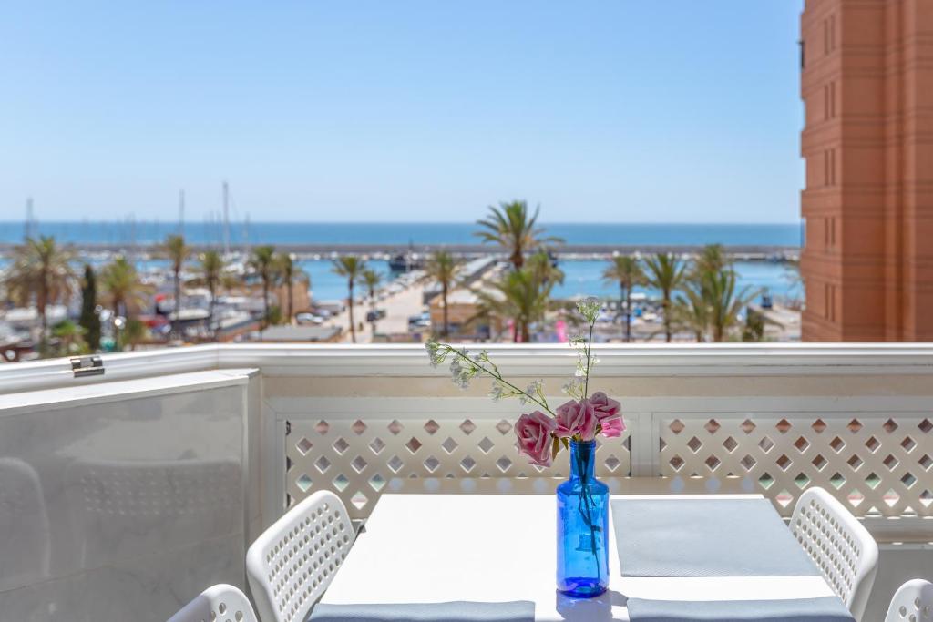 a table with a vase with flowers on a balcony at Marina view apartment in Fuengirola