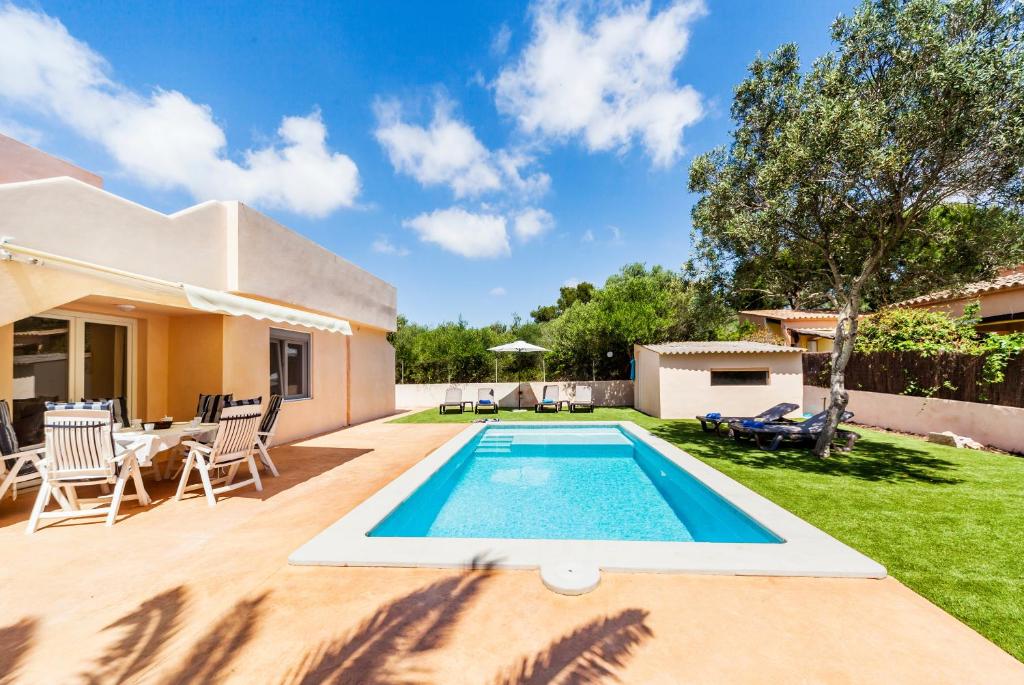 a swimming pool in the backyard of a house at Casa Antonio in Cala Llombards