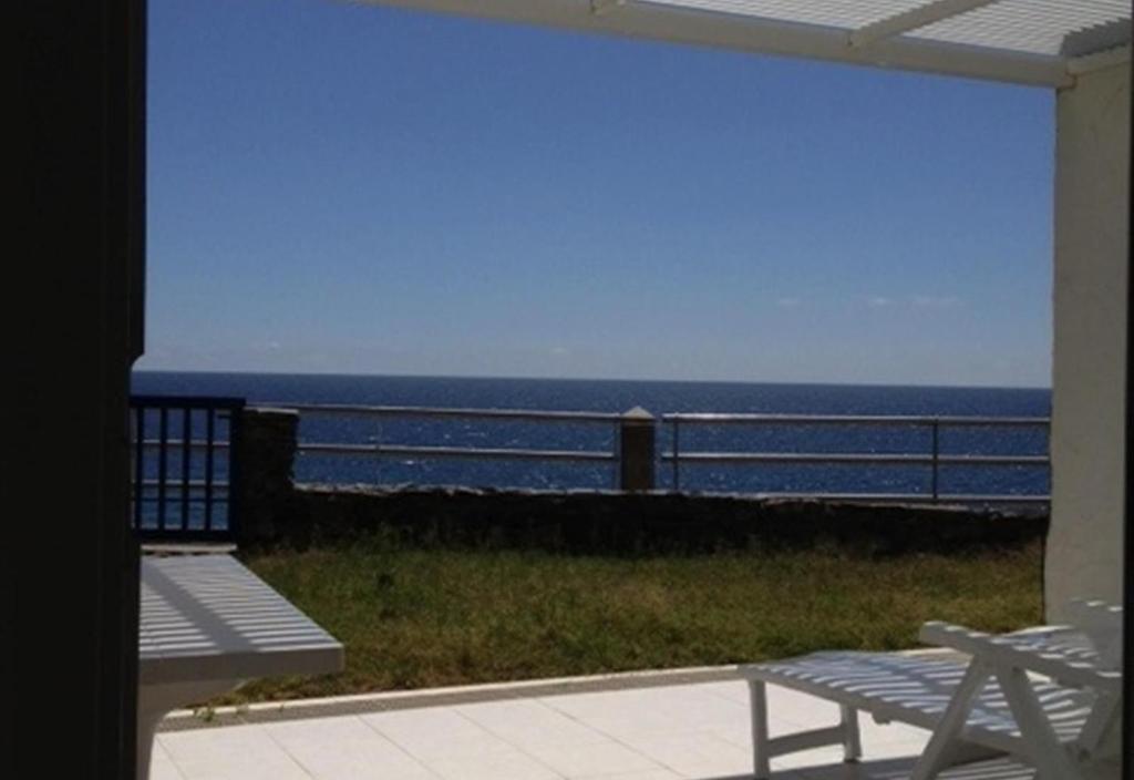 a view of the ocean from a patio with a bench at Nueva Baviera 42 in San Bartolomé
