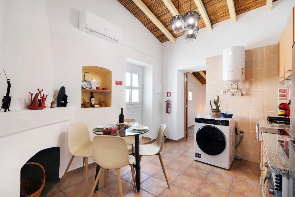 a kitchen and dining room with a table and chairs at Casa Gotinha d' Água in Alcaria Ruiva
