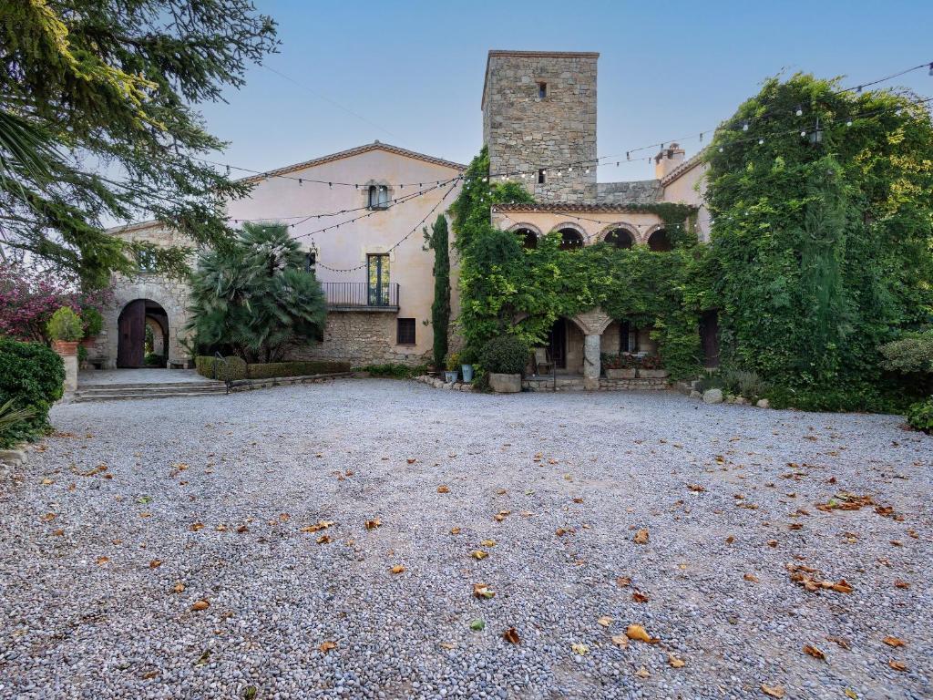a large house with a gravel driveway in front of it at Casa Romaní in El Bruc