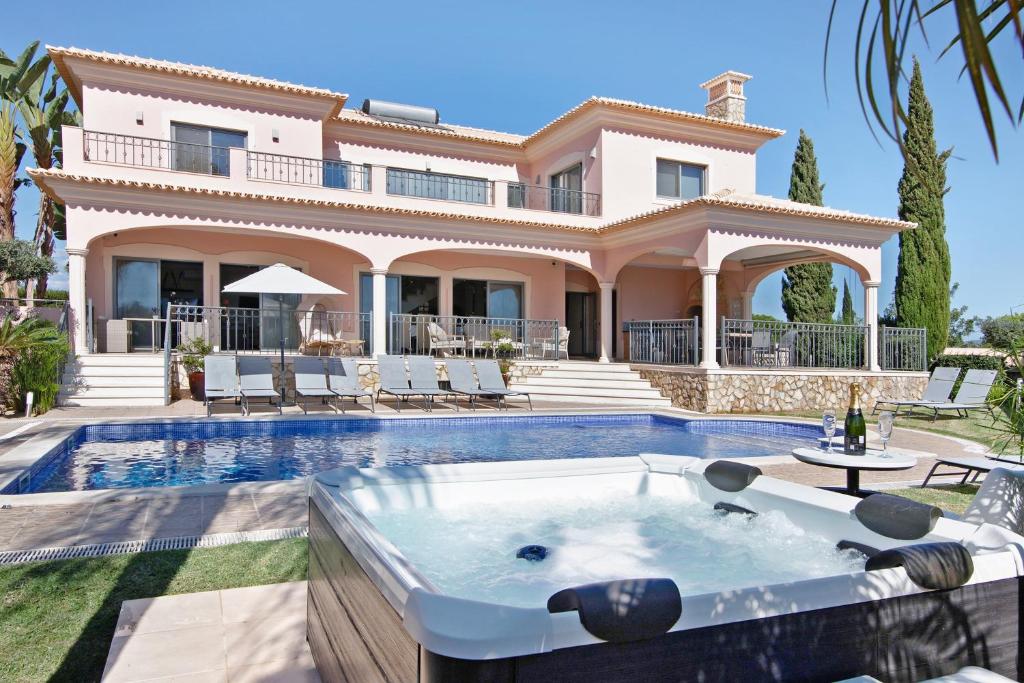 a villa with a swimming pool and a house at Sunshine Villa em Vilamoura in Vilamoura