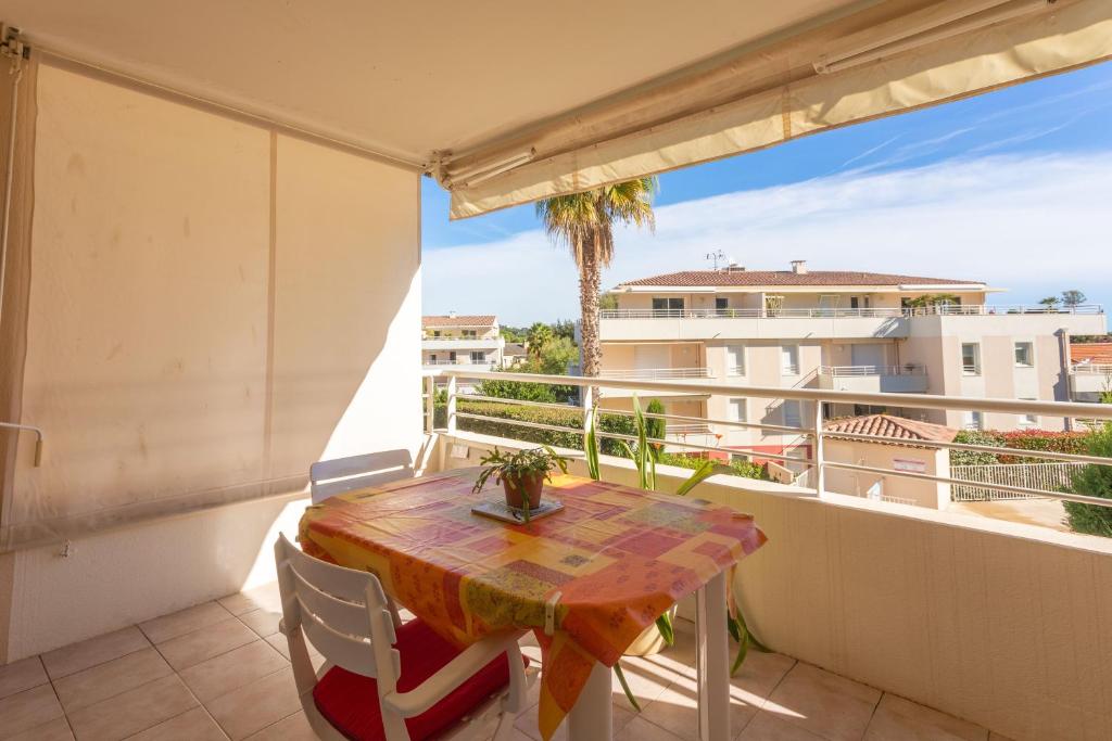 a balcony with a table and a view of a building at Petit Paradis à Cavalaire in Cavalaire-sur-Mer