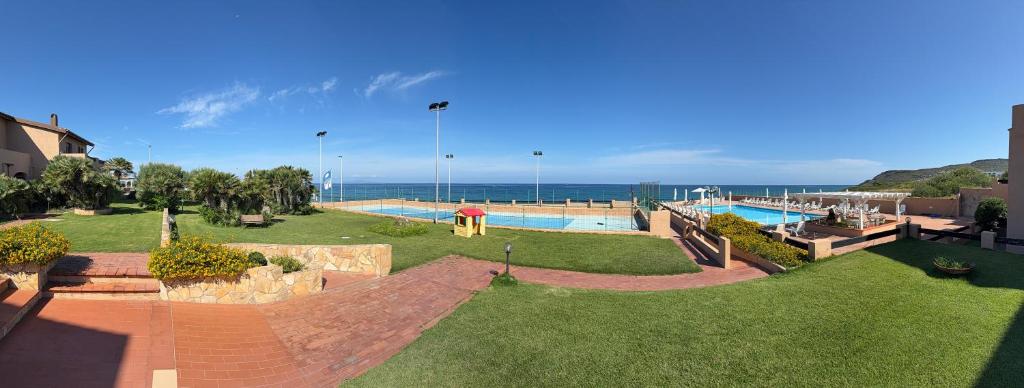 a large yard with a swimming pool and the ocean at Villa Elena in Castelsardo