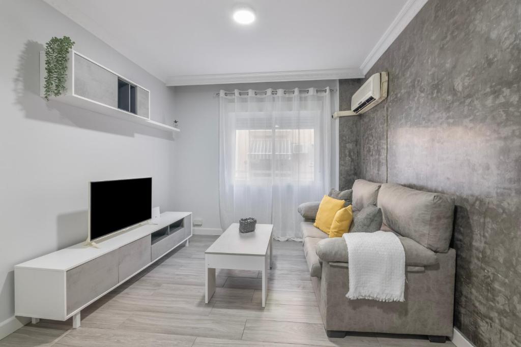 a living room with a couch and a tv at Grey House in Huelva
