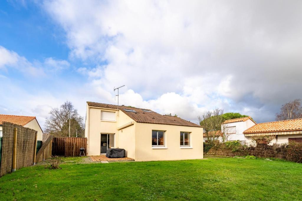 a house in a yard with a green lawn at Cap sur la détente - 128 in Pornic