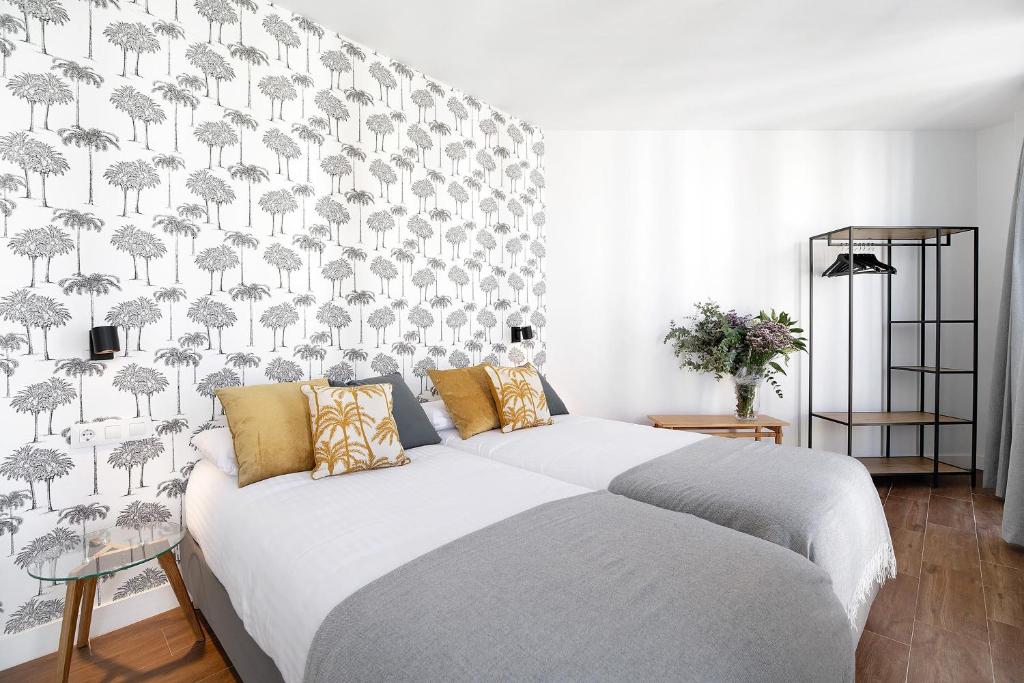 a bedroom with a large white bed with a wallpaper at Casa Milano 2 in Jerez de la Frontera