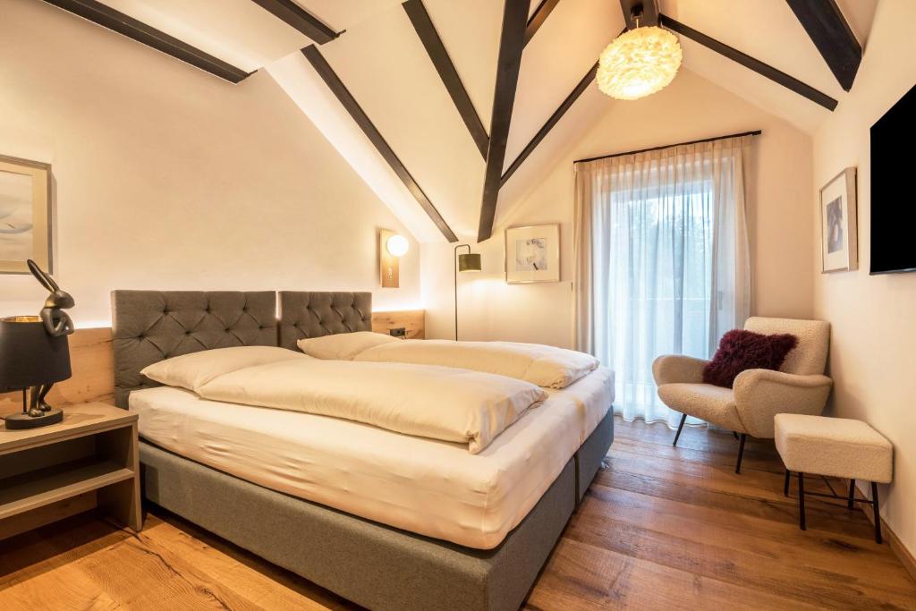 a bedroom with a large bed and a chair at Residence Skutial App Schlern in Castelrotto