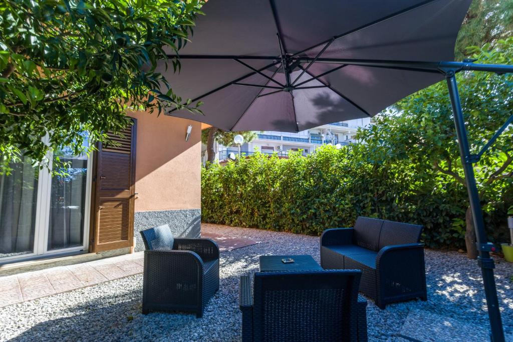 an umbrella and two chairs and a table at Casa Gioiosa Holidays in Gioiosa Marea