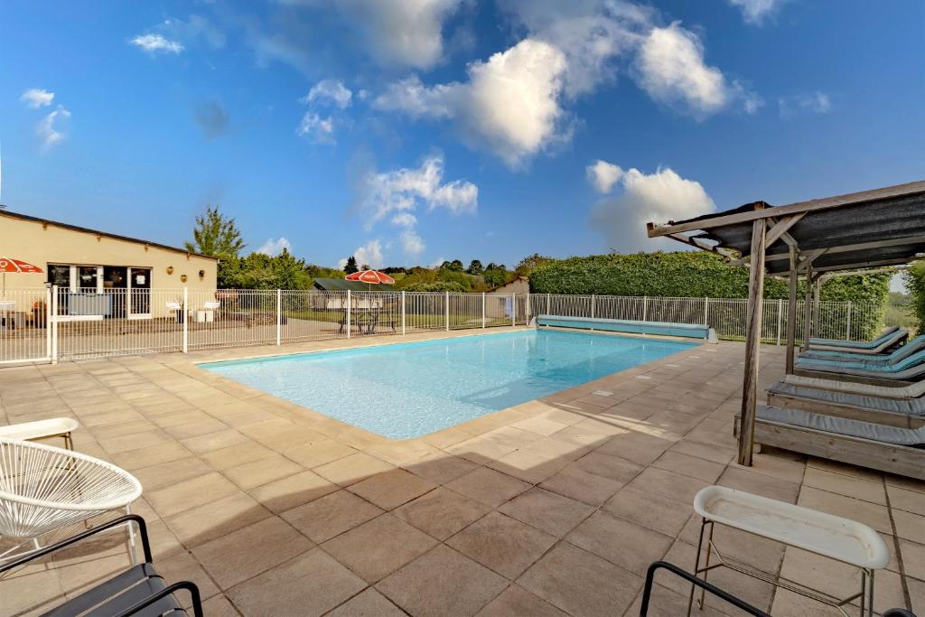 a swimming pool with chairs and a pavilion at Gite Bellevue in Paulin