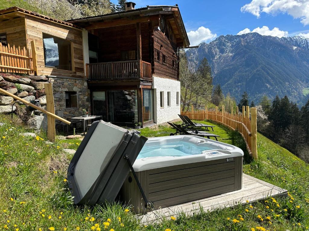 a hot tub and a tv in front of a house at Bergchalet h e i m a t in San Martino