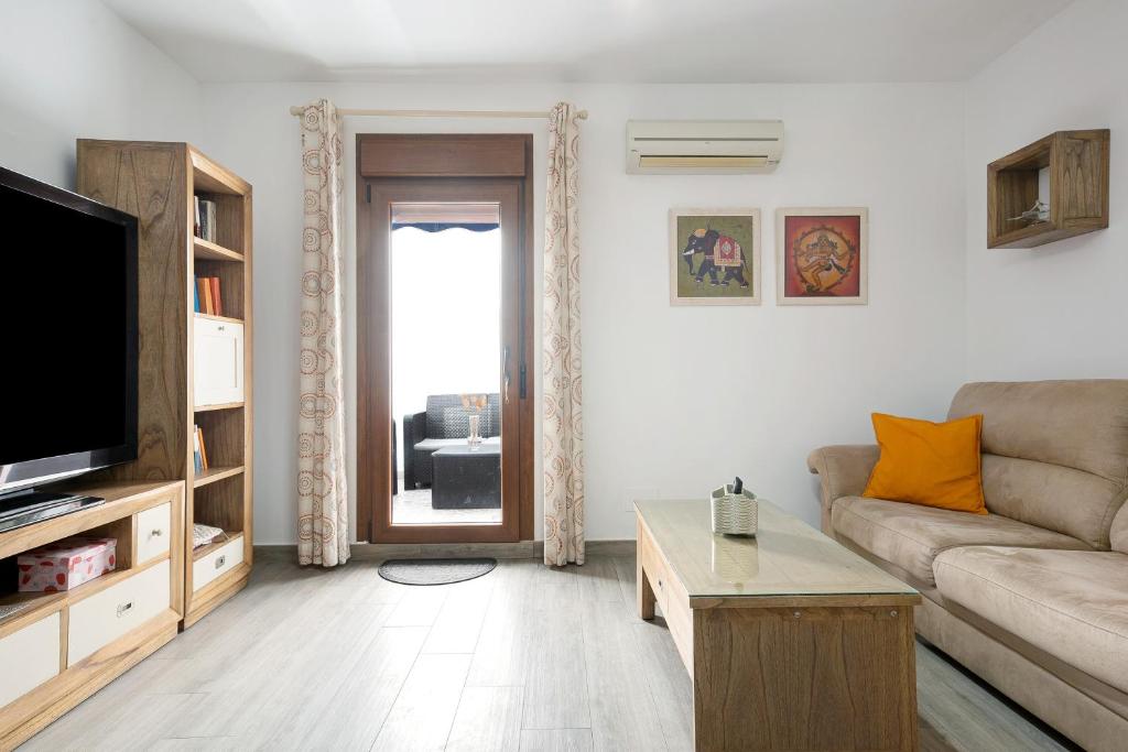 a living room with a couch and a tv at Reina's in Vejer de la Frontera