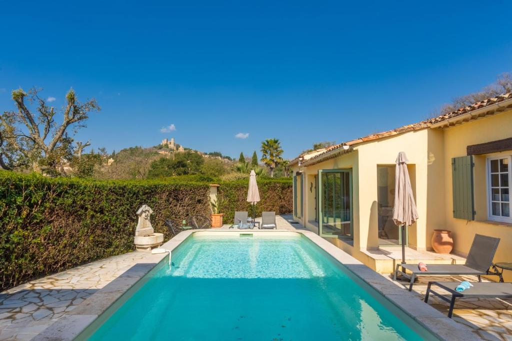 a swimming pool in the backyard of a house at La Petite Maison Jaune in Grimaud