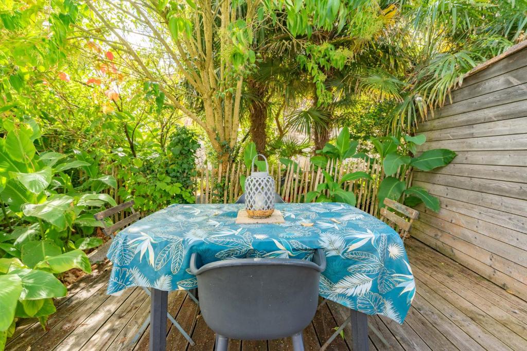 a table in a garden with a blue table cloth at Gite Du Porche Bis in Chaillevette