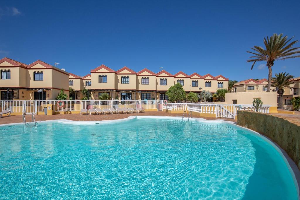 a large swimming pool in front of some apartments at Casa Curro Costa Calma in Costa Calma