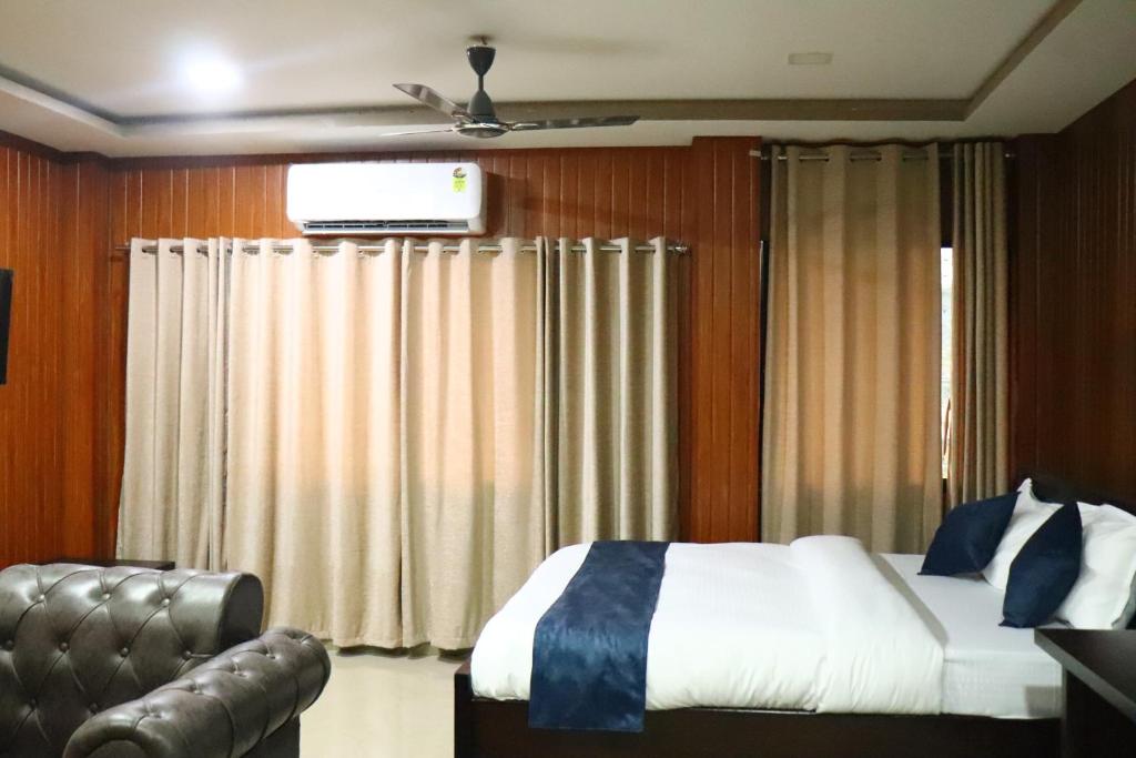 a bedroom with a bed and a couch and a television at Hotel Golden Mahseer in Tezu