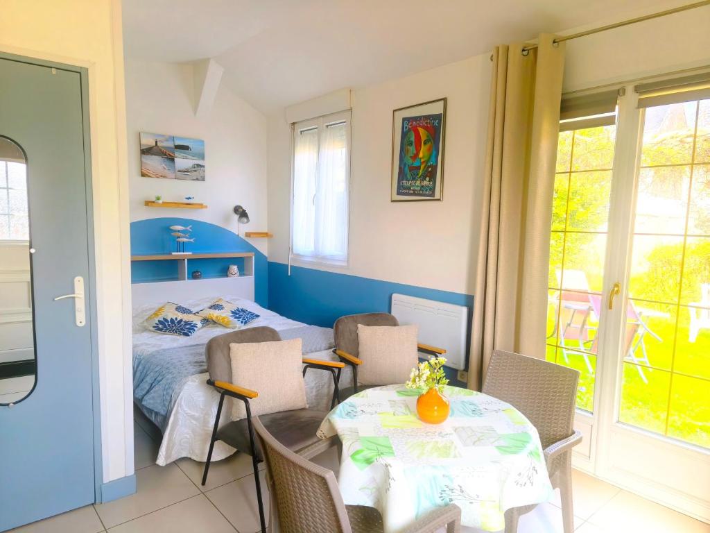 a bedroom with a bed and a table and chairs at Petit Gîte Douillet L'abri Côtier in Saint-Léonard