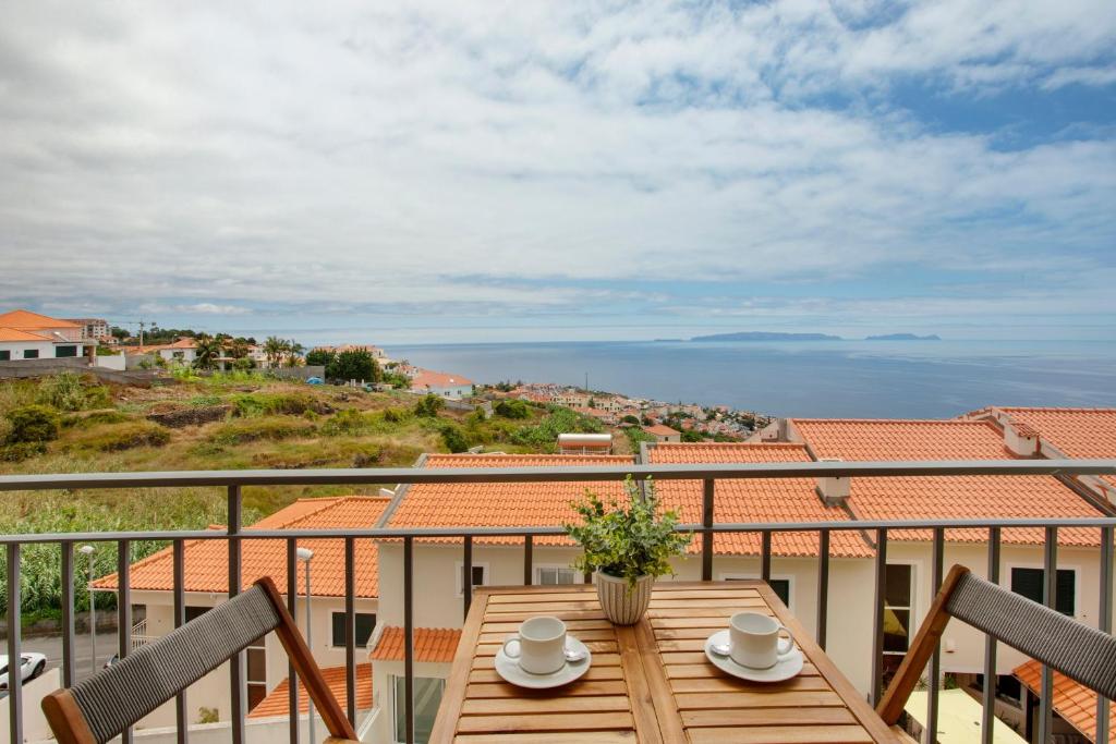a table on a balcony with a view of the ocean at Ti Clara View Apartment in Caniço