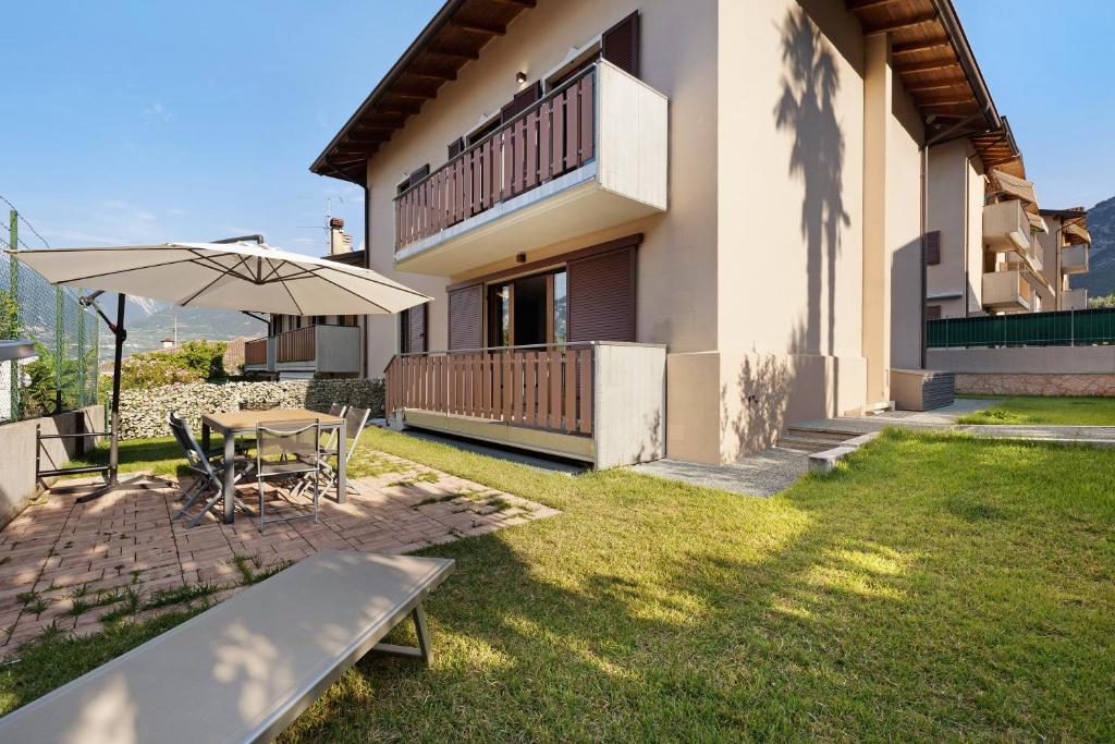 a patio with a table and an umbrella in a yard at Katzemburg 9999 in Arco