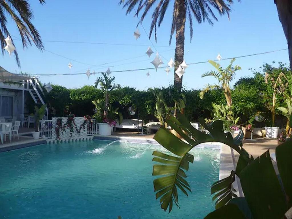 a swimming pool with white paper kites hanging above it at Apartamento Ciel Azul in Santa Eularia des Riu