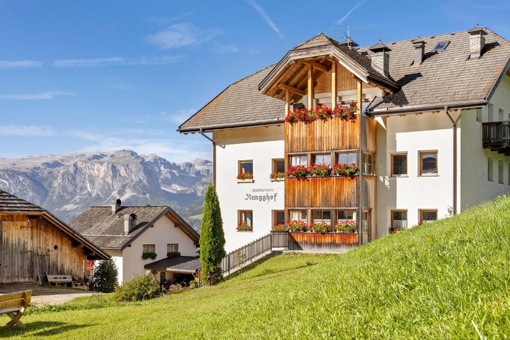 ein Gebäude mit Blumenkästen darauf auf einem Hügel in der Unterkunft Rungghof in Wengen