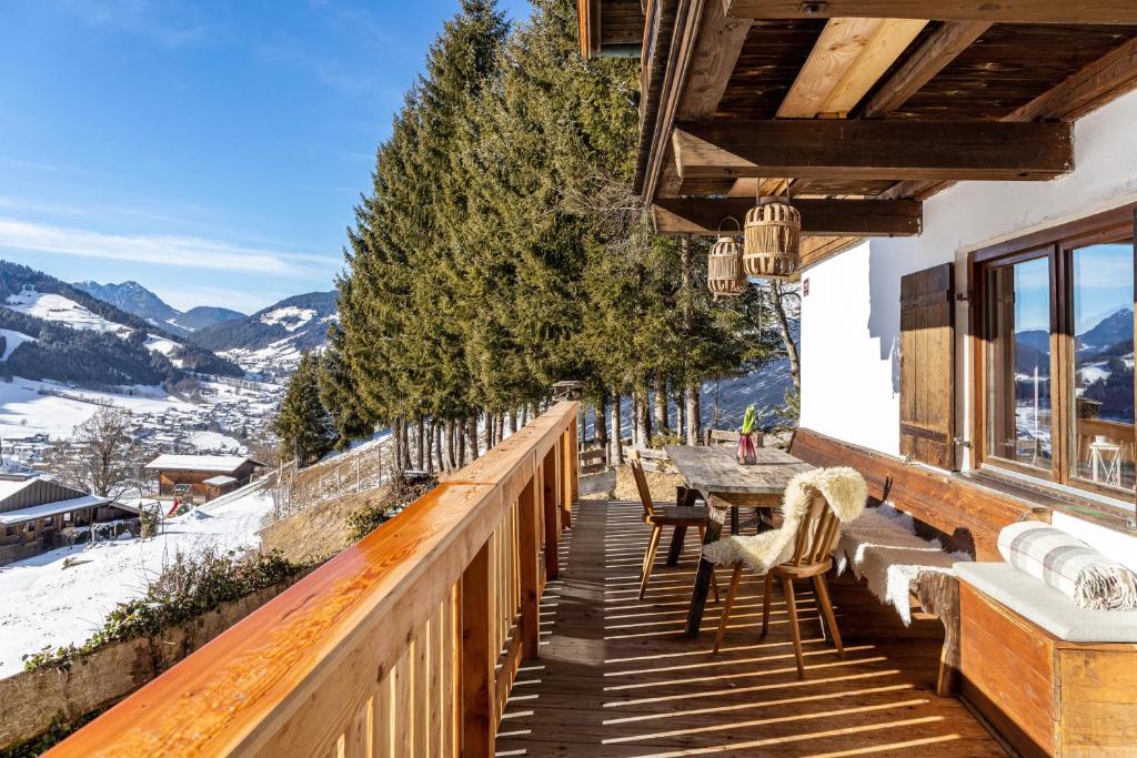 a balcony of a house with a table and chairs at Sonnenhütte Wildschönau Erdgeschoß in Grafenweg