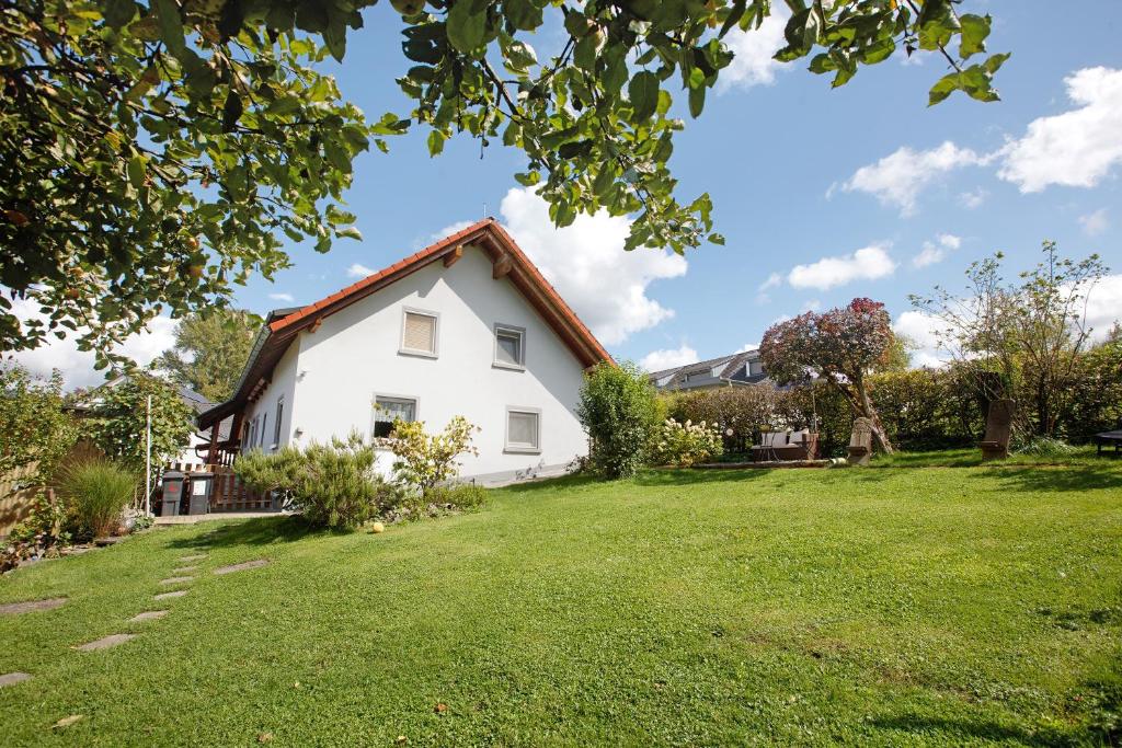a white house with a green yard at Ferienwohnung Hildegard in Rappersweier