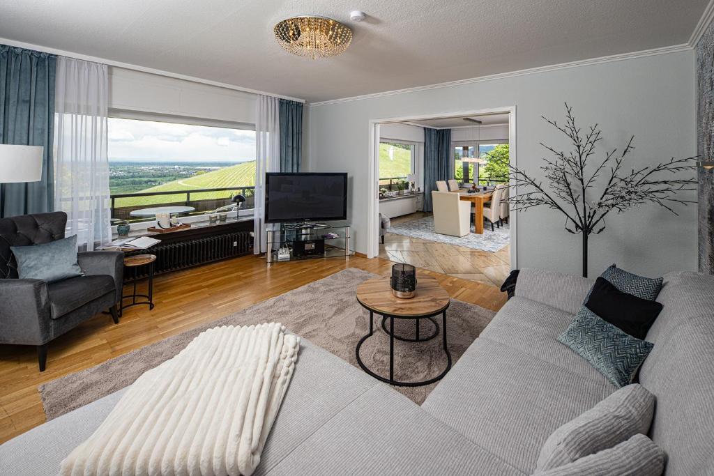 a living room with a couch and a tv at Baden-Chalet - Panoramablick in Bühl