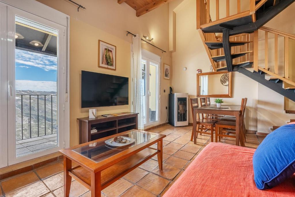 a living room with a staircase and a tv at The Maisonette Sierra Nevada in Monachil