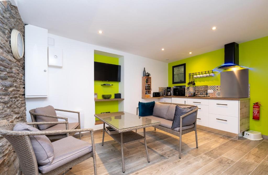 a living room with a glass table and chairs at Petite Maison Malestroyenne in Malestroit