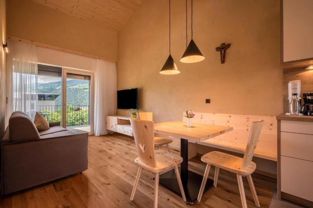 a kitchen and dining room with a wooden table and chairs at Sommersbergerhof 1968 in Bressanone