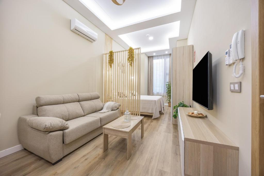 a living room with a couch and a tv at Apartamentos Brisas de Cádiz 3 in Cádiz
