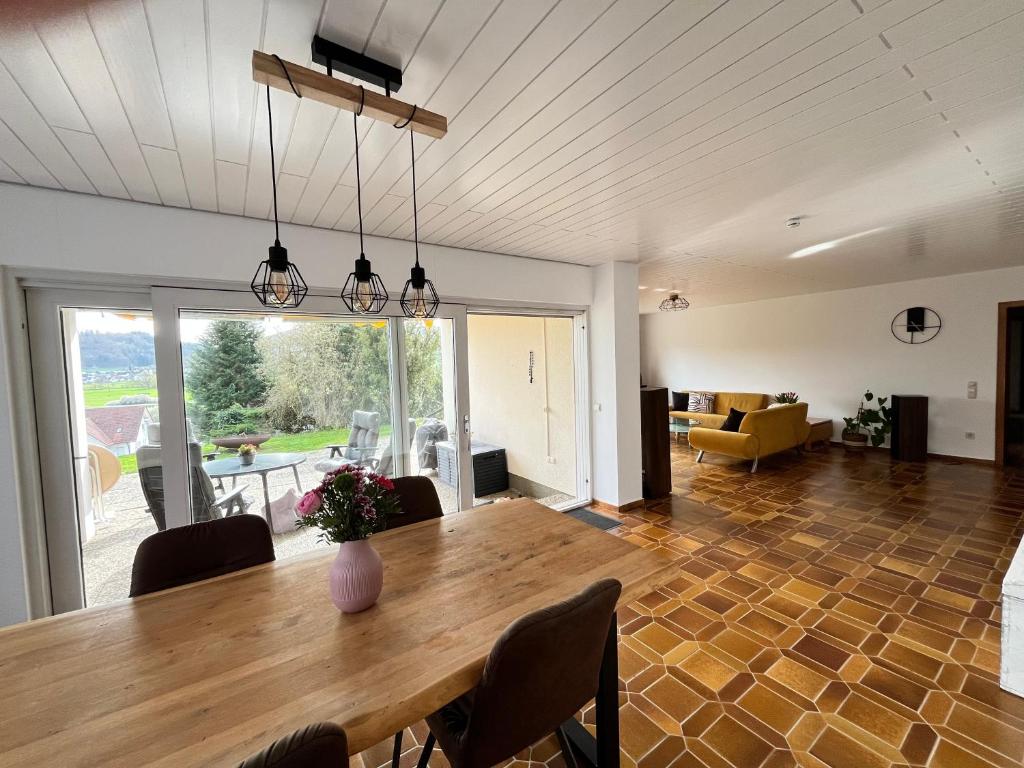 a dining room and living room with a wooden table at Terrasse mit Ausblick in Biedenkopf