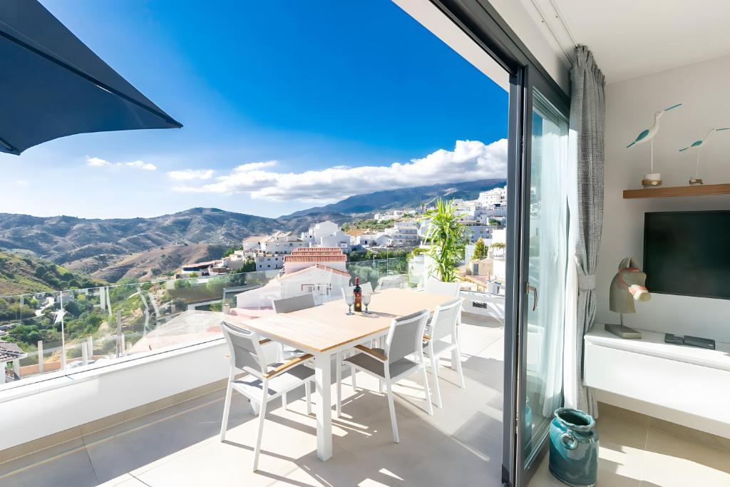 a dining room with a table and chairs and a large window at Stunning apartment in Cómpeta in Cómpeta
