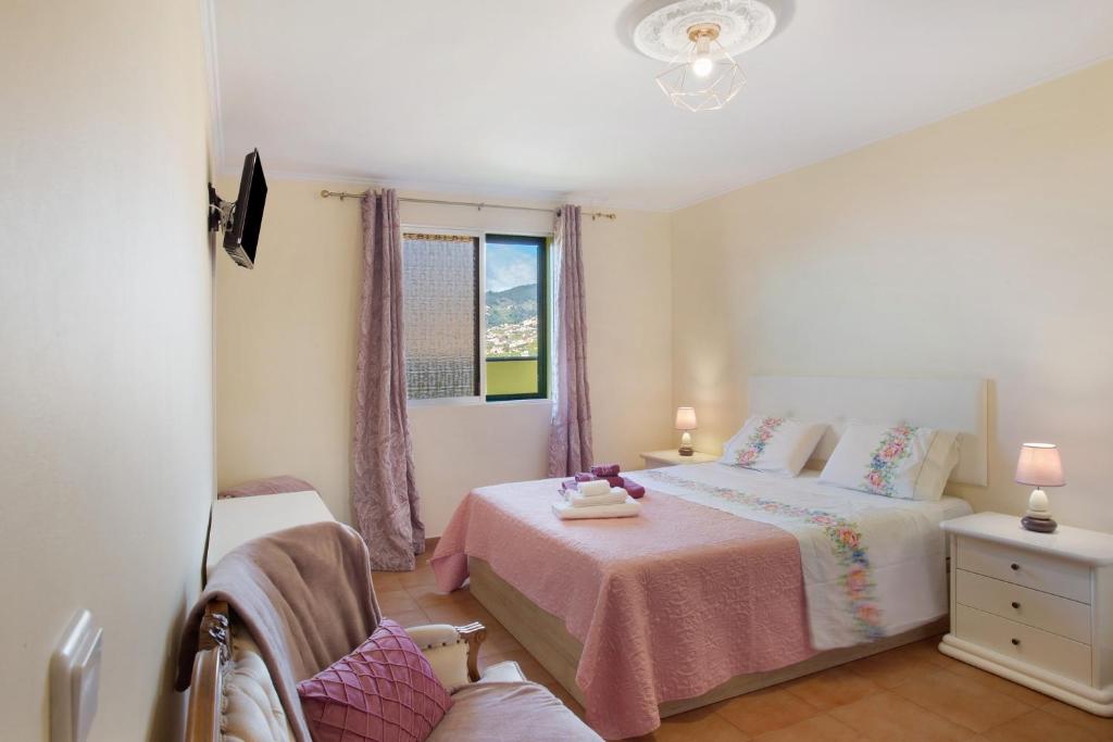 a bedroom with a bed and a window at Levada Residence in Funchal