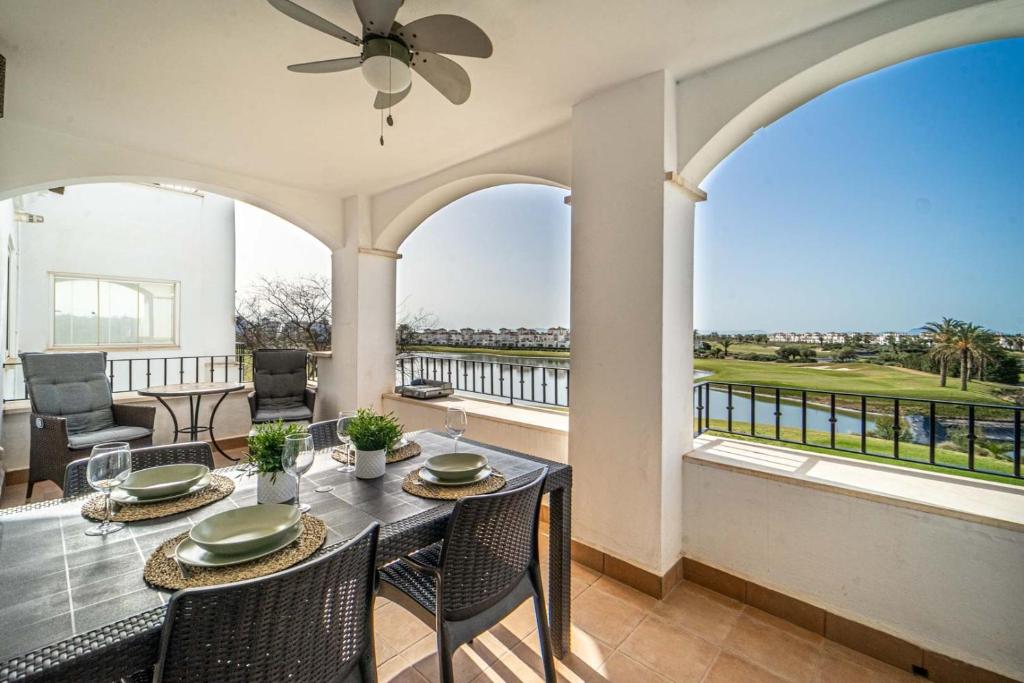 a dining room with a table and chairs and a balcony at Casa verde in Roldán