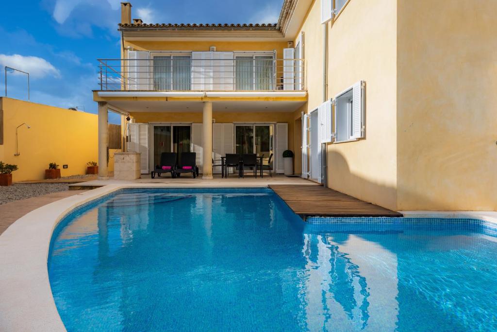 a swimming pool in front of a house at Villa Can Gaya in Alcudia