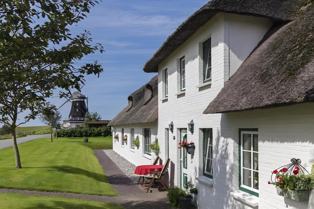 a row of white houses with a thatched roof at Dat Möhlenhus Peter Jensen in Pellworm