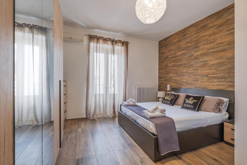 a bedroom with a bed and a wooden wall at Narcê – Coastal Retreat in Porto Cesareo