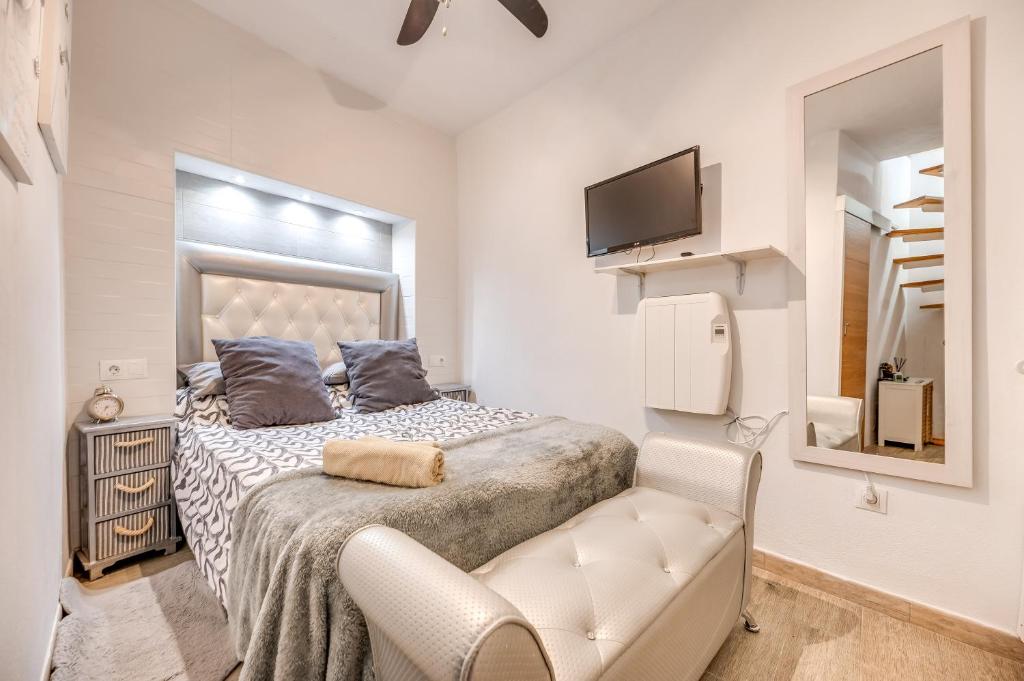 a bedroom with a bed with a chair and a tv at Casa cerca de Marbella in Ojén