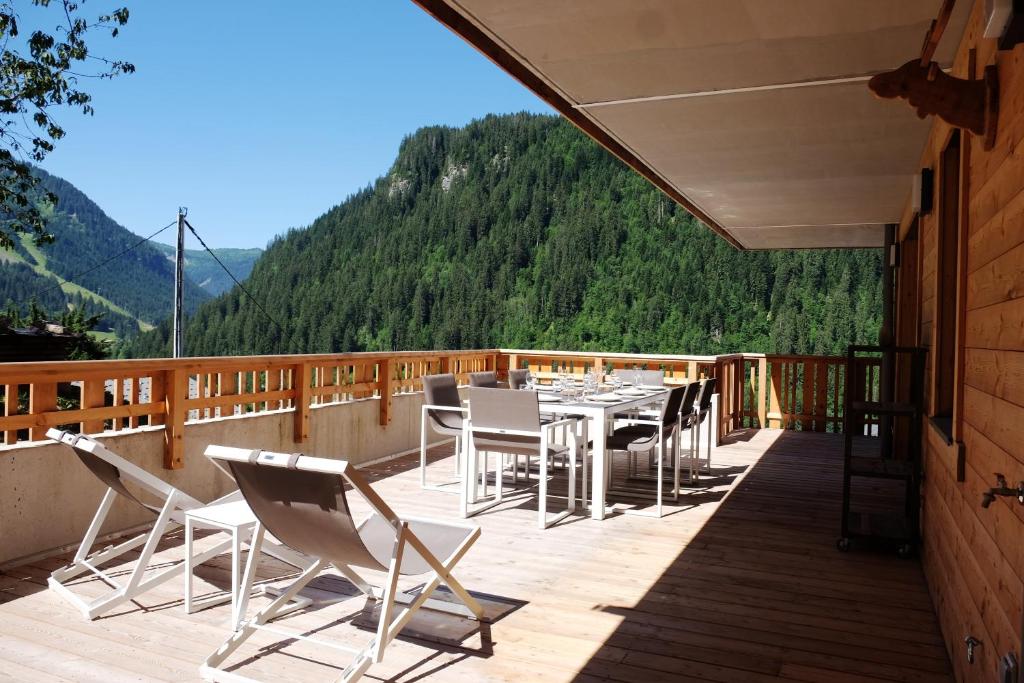a patio with a table and chairs on a deck at Loges blanches b101 Roca immobilier in Châtel