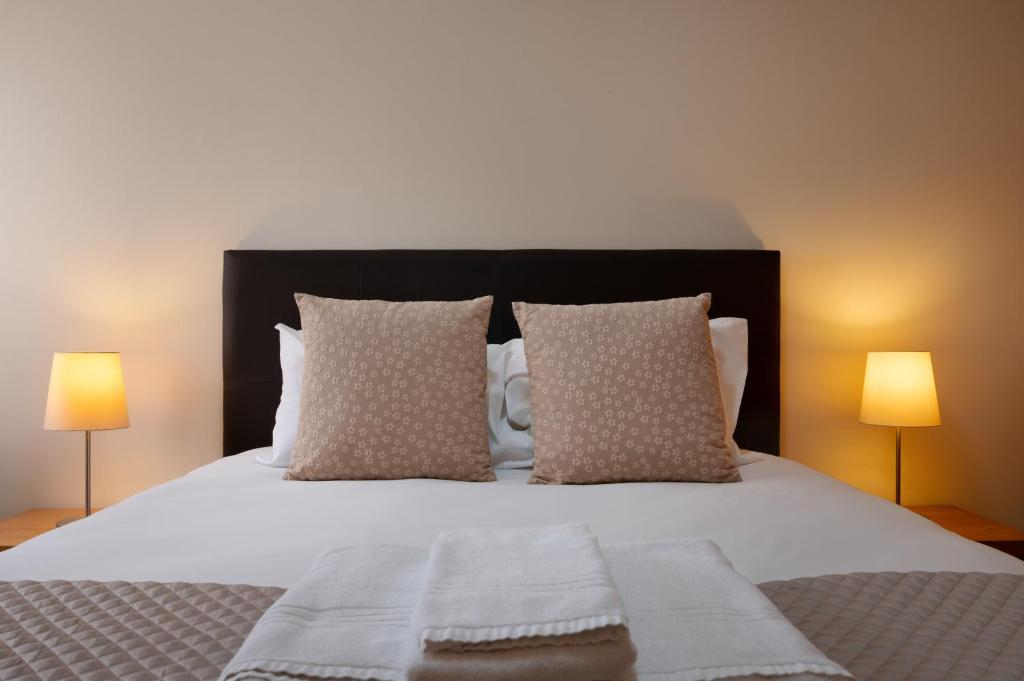 a bedroom with a bed with pillows and two lamps at Wander Unwind - Wine Cellars in Vila Nova de Gaia