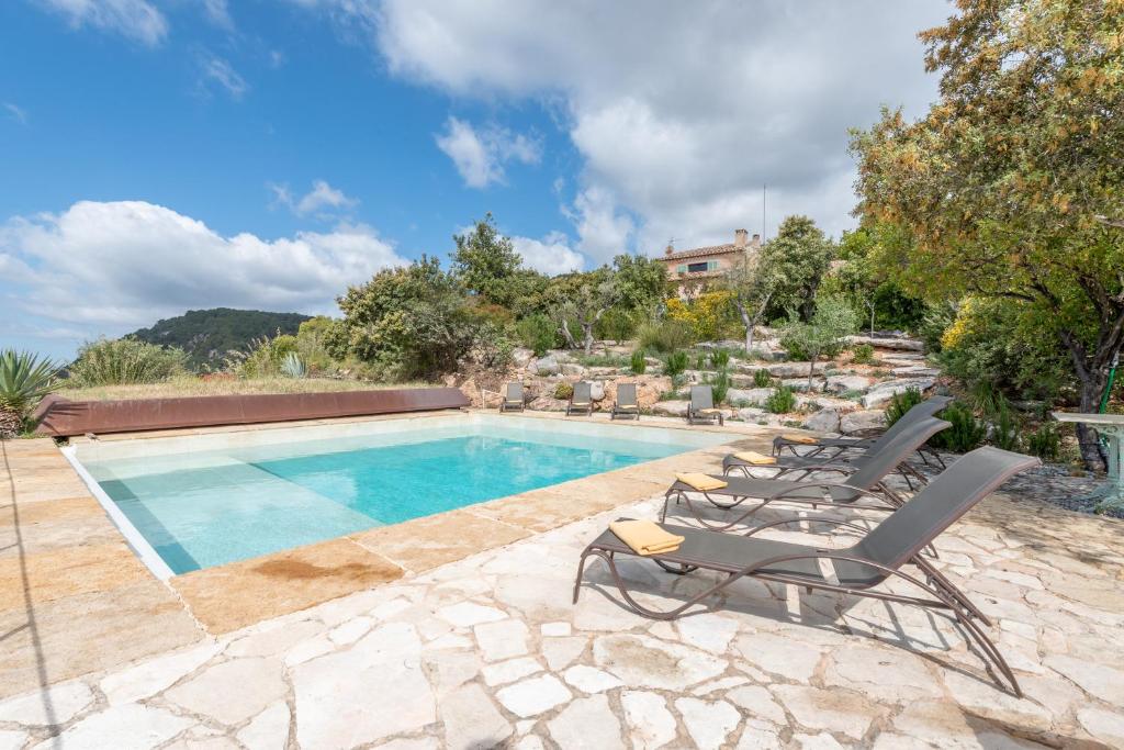 a swimming pool with lounge chairs next to a house at Casa Roca Esporles in Esporlas