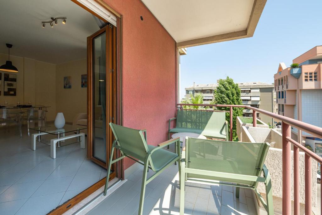 a balcony with chairs and a table on a building at P012 Apartment in Cagliari