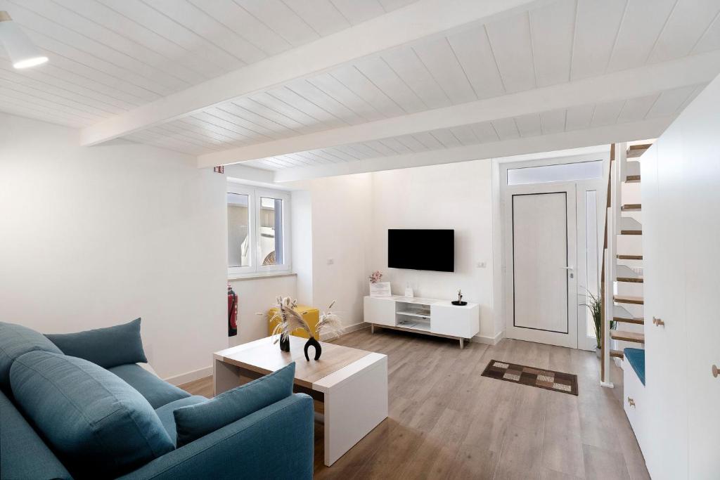 a living room with a blue couch and a tv at Casa Quattrocchi in Barano d'Ischia