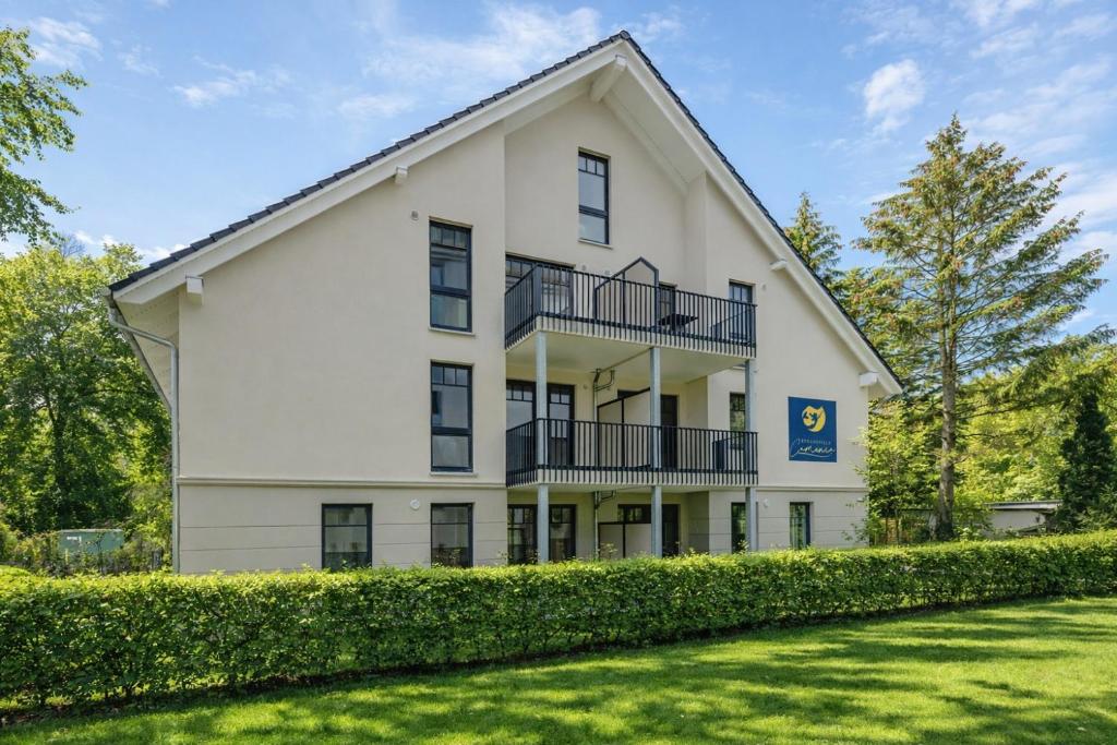 a large white building with a large yard at Villa Camenia in Kühlungsborn