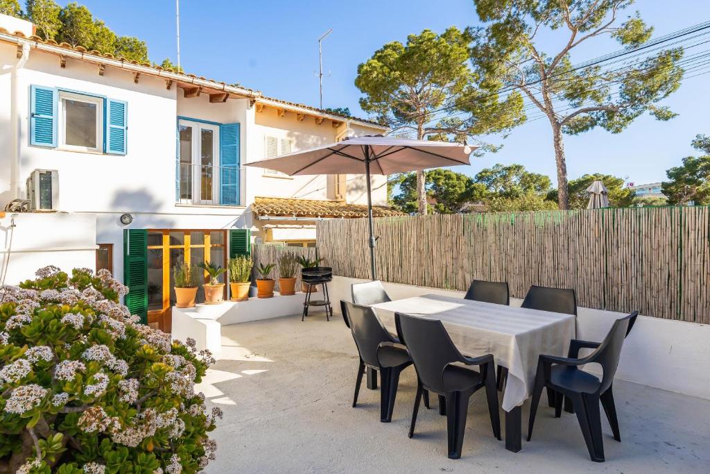 a patio with a table and chairs and an umbrella at Villa Lucia in Portocolom