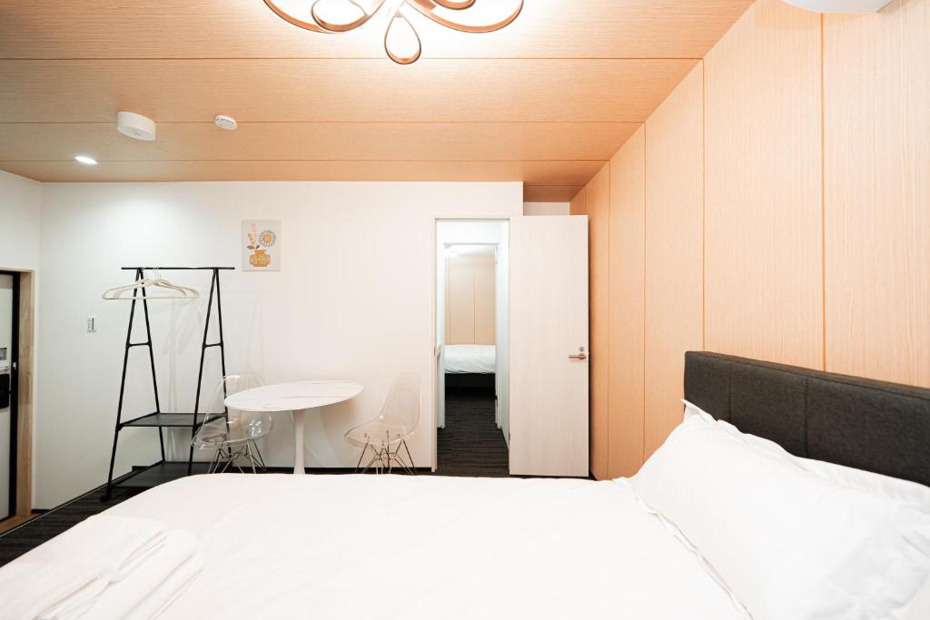 a bedroom with a bed and a room with a table at GLOU Akasaka Inn in Tokyo