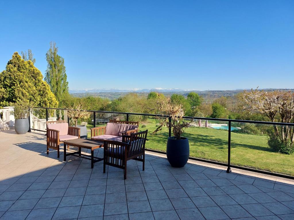 a patio with a table and chairs and a view at Le Cocon Des Roches in Cessieu